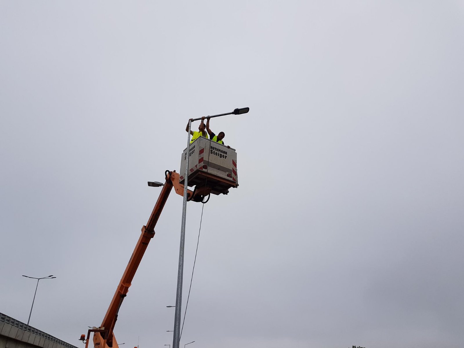 инж.Васил Димитров и негов колега извършват монтаж на улични лампи на северната скорстна тангента в гр.София с вишка с подвижен кош.